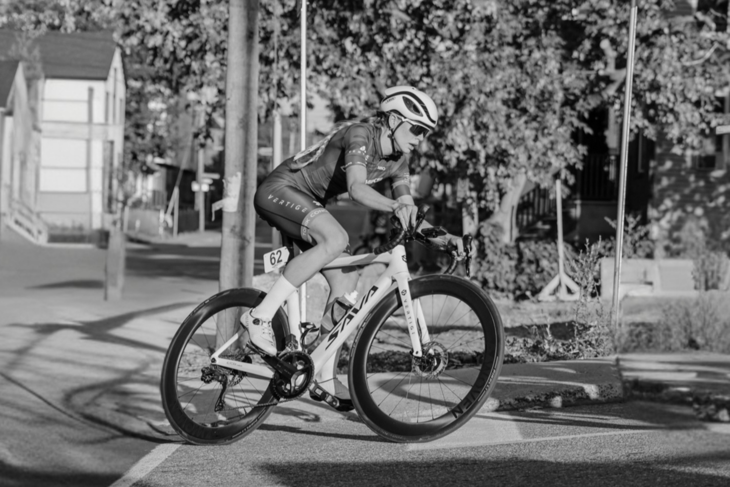 Dynamik girl riding a bicycle on a sidewalk with trees and buildings in the background